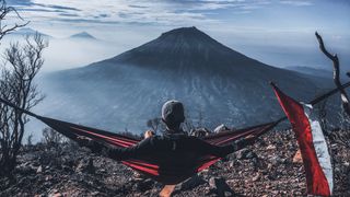 Camper in a hammock with volcano in the background