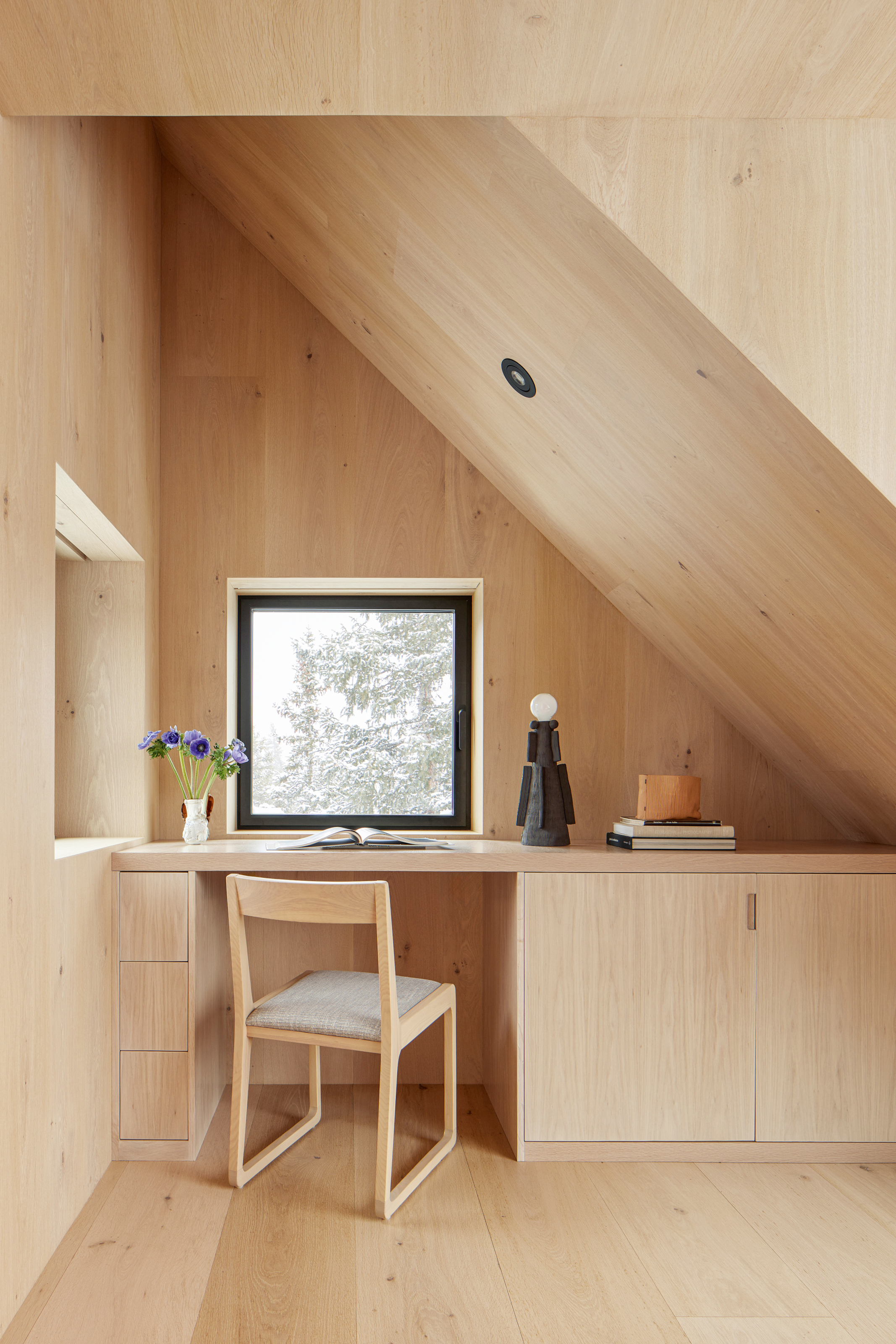 Home office area under the eaves clad entirely in white oak
