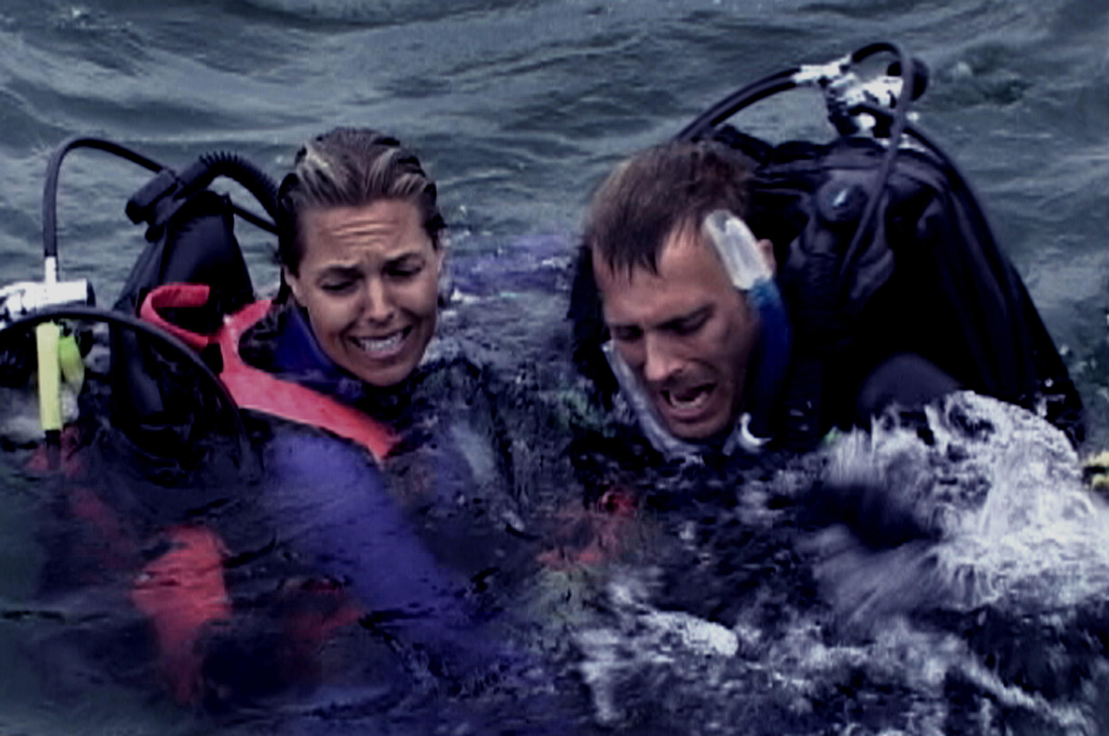 Blanchard Ryan como Susan y Daniel Travis como Daniel entra en pánico mientras un tiburón nada debajo de ellos en aguas abiertas