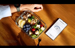 A photo of a Samsung phone showing the Samsung Health app showing the antioxidant index, next to a plate of healthy-looking food.