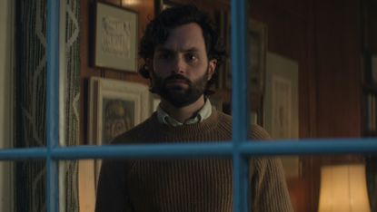 penn badgley as joe goldberg staring out the window in you on netflix