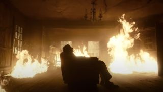 Bradley Cooper sleeping in a room of fire in Nightmare Alley.