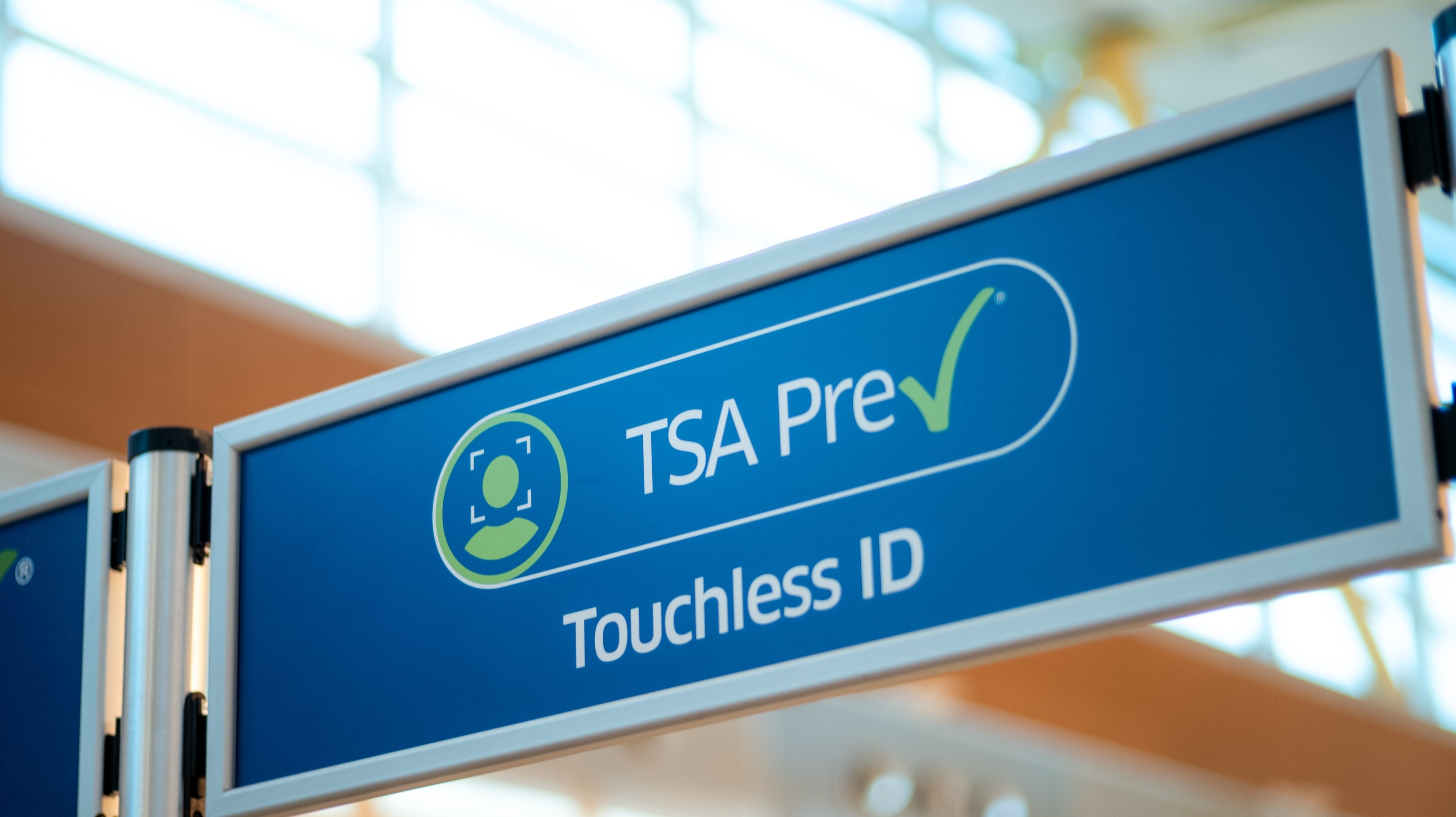 A close up of an airport security sign designating a lane for travelers with TSA PreCheck Touchless ID.