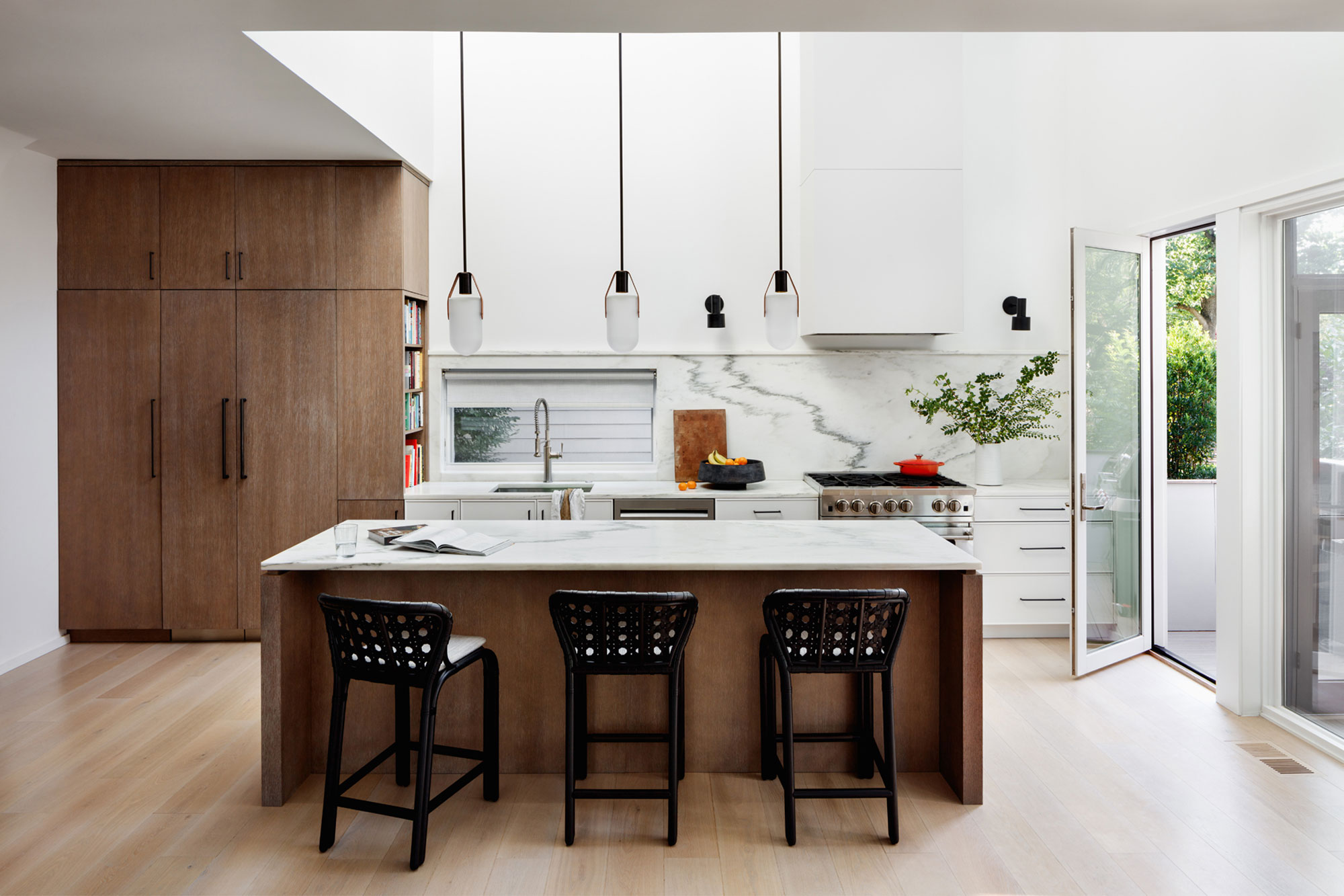 a wood kitchen with a double height ceiling and skylight above