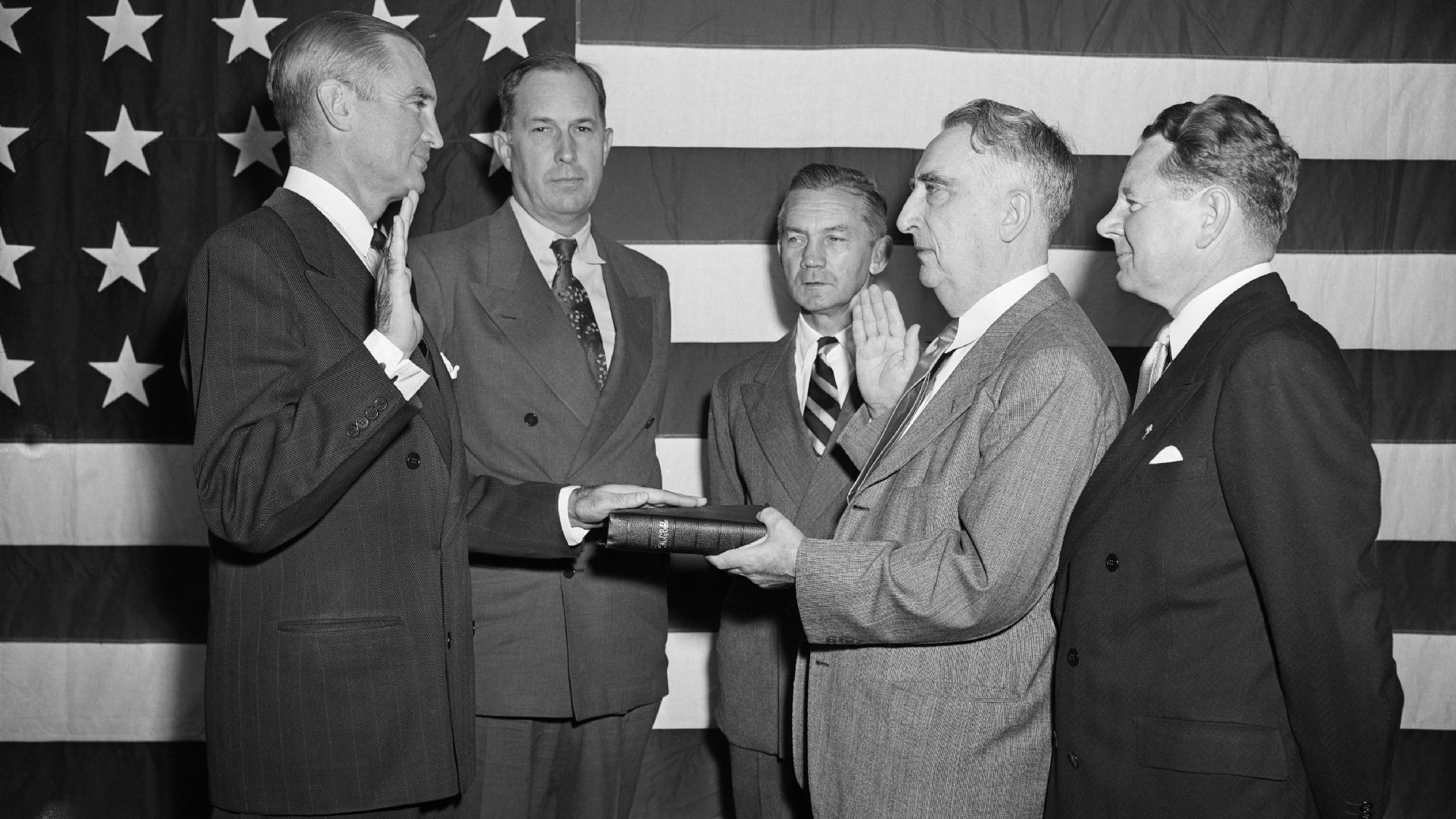 W. Stuart Symington is sworn in as Secretary of the Air Force in front of a large US flag