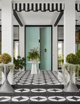 grand front porch with black and white tiles, Tiffany blue door and planters