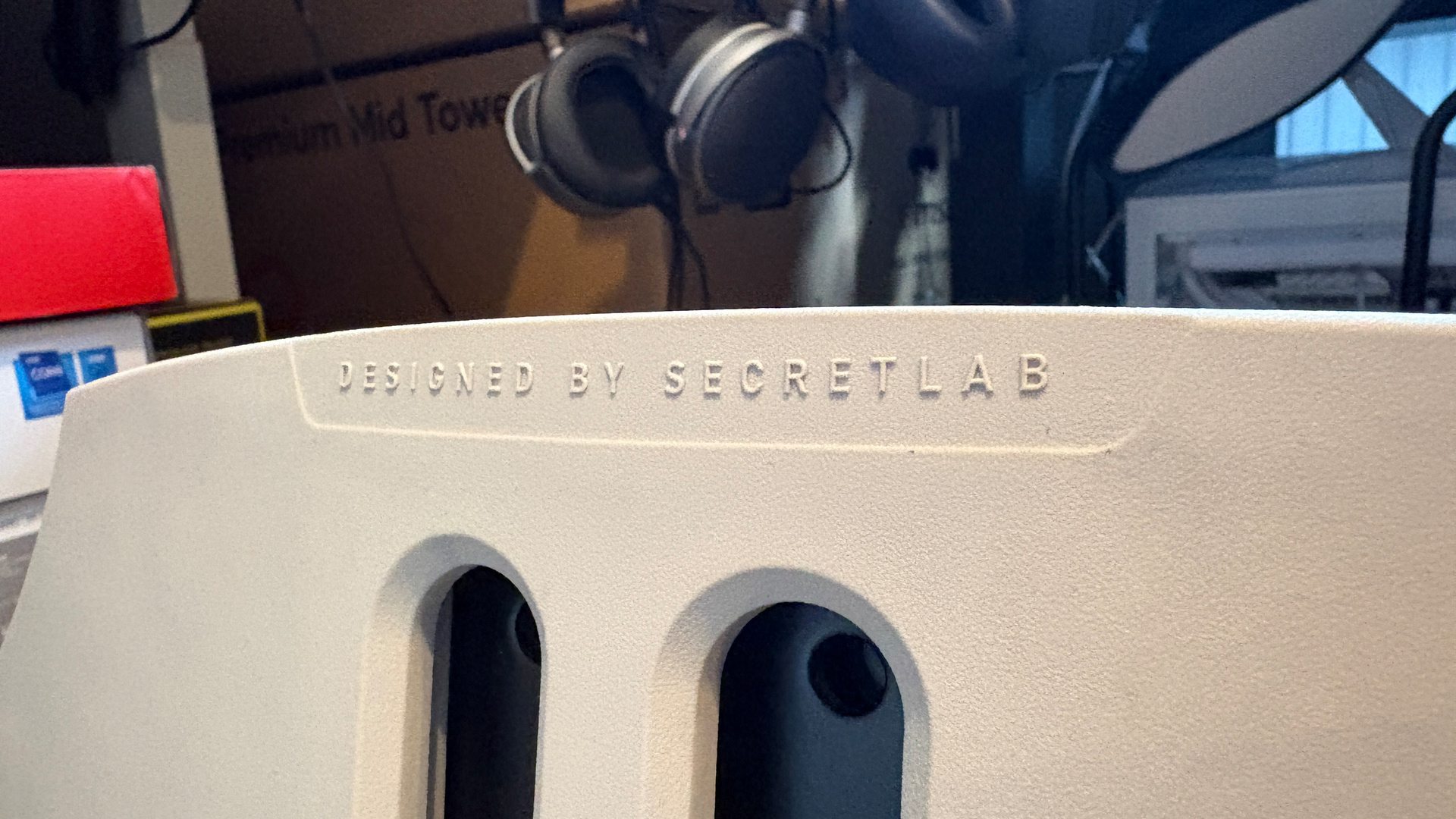 A Secretlab Atlas gaming chair in a home office during set-up and after it's completed.