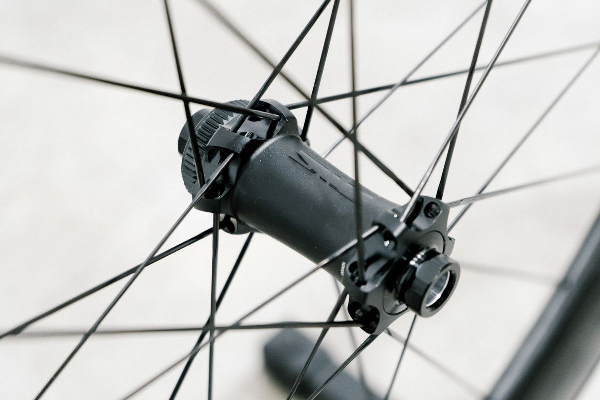 An aero road wheel stands against a white wall
