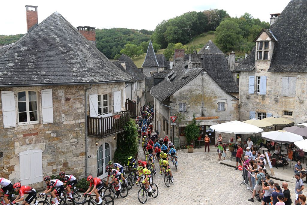 LIMOGES FRANCE AUGUST 18 A general view of the peloton passing through Turenne Village while fans cheer during the 55th Tour du Limousin Nouvelle Aquitaine 2022 Stage 3 a 1817km stage from Donzenac to Malemort TDL2022 on August 18 2022 in Limoges France Photo by Dario BelingheriGetty Images