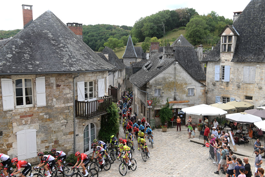 LIMOGES FRANCE AUGUST 18 A general view of the peloton passing through Turenne Village while fans cheer during the 55th Tour du Limousin Nouvelle Aquitaine 2022 Stage 3 a 1817km stage from Donzenac to Malemort TDL2022 on August 18 2022 in Limoges France Photo by Dario BelingheriGetty Images