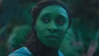 Cynthia Erivo looking back with a slight smile in the forest in Wicked. 