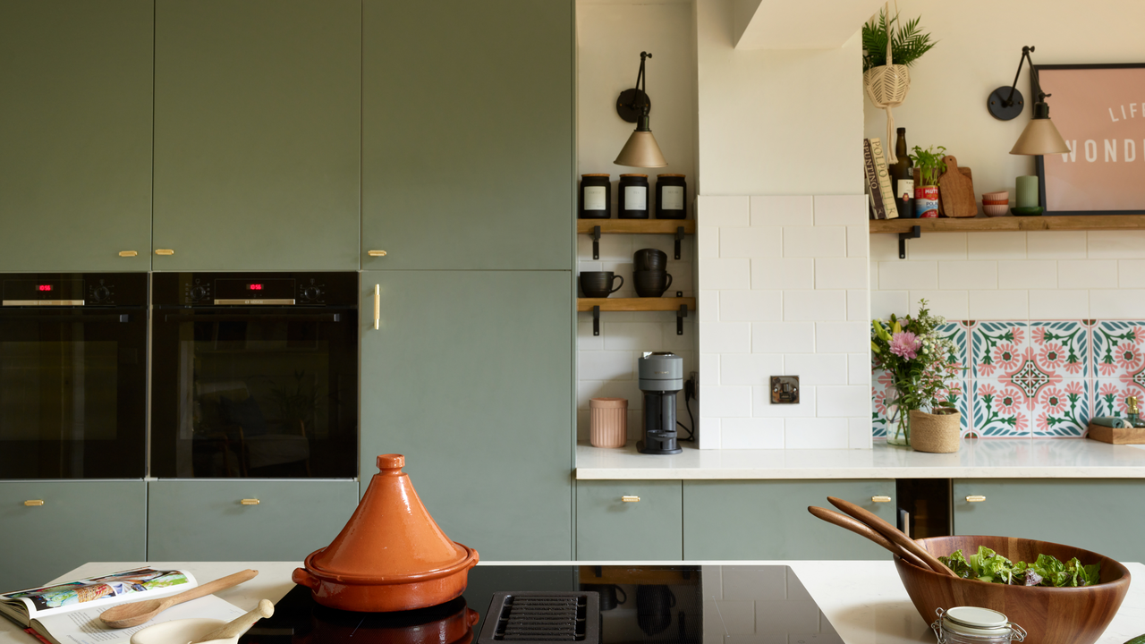 reen/blue cupboards, gold leaf island unit, large patterned tiles above the sink. Wooden dining table, with wooden slatted wall behind.