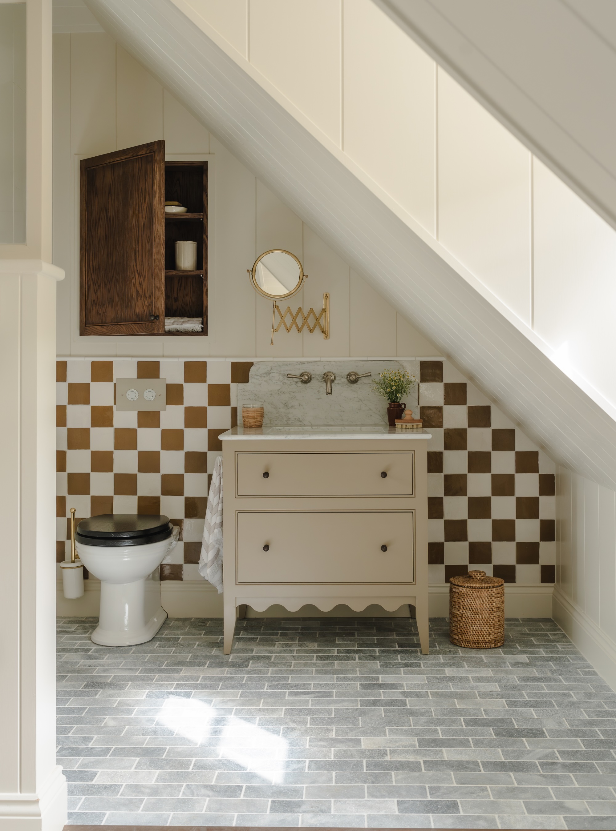 bathroom with checked tiles, scalloped vanity unit and hidden wall cupboard