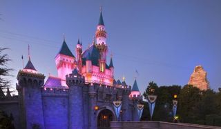 Sleeping Beauty's Castle at Disneyland lit up at dusk