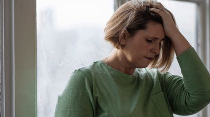 Woman clasping her head in her hands