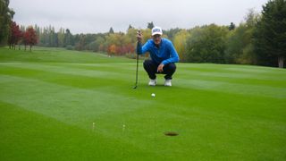 PGA pro Barney Puttick lining up a putt as Essendon Golf Club