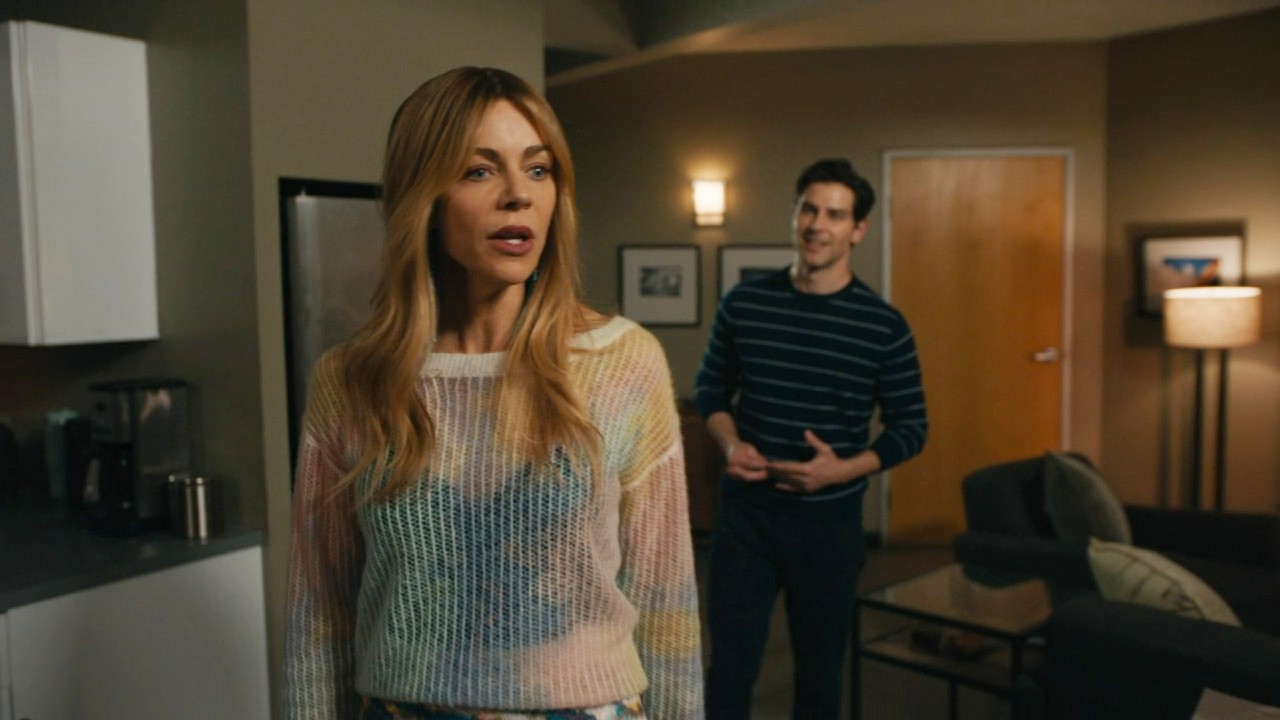 David Giuntoli standing behind Kaitlin Olson in High Potential.