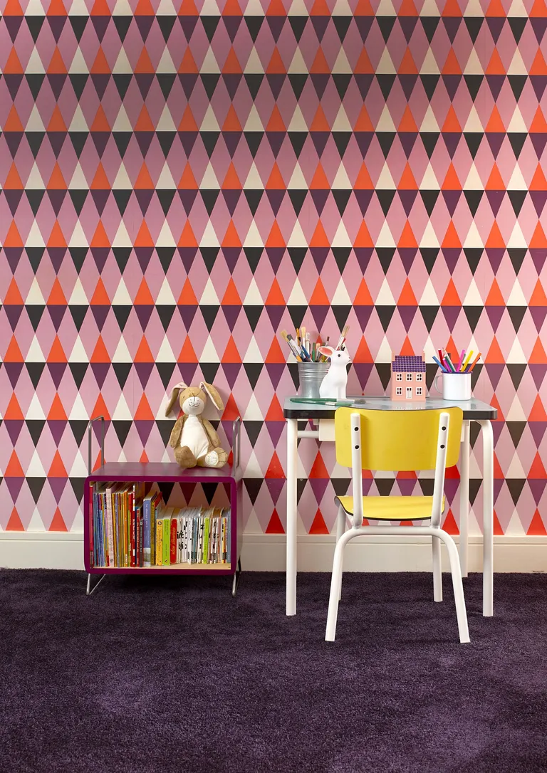 Patterned walls with child's desk and yellow chair