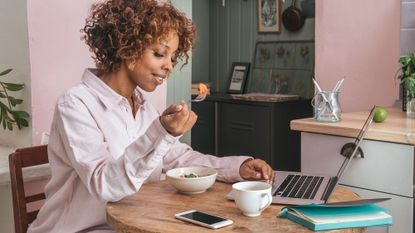 Woman eating brain power foods whilst she works