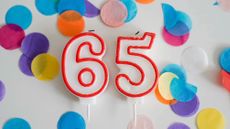 Number 65 birthday candles with colorful confetti 