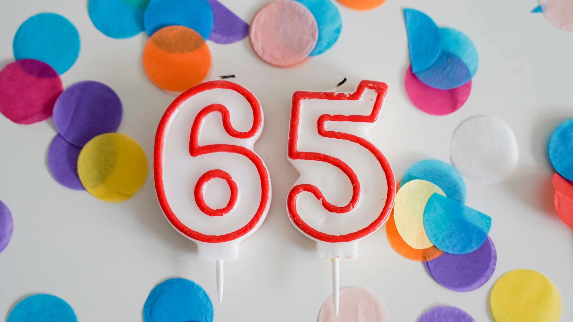 Number 65 birthday candles with colorful confetti 