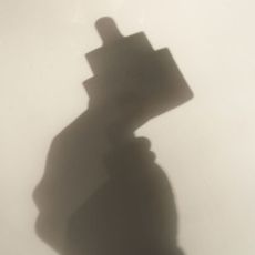 The shadow of a serum bottle.