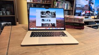 The 2024 MacBook Air M3 on a wooden table in front of a bookshelf.