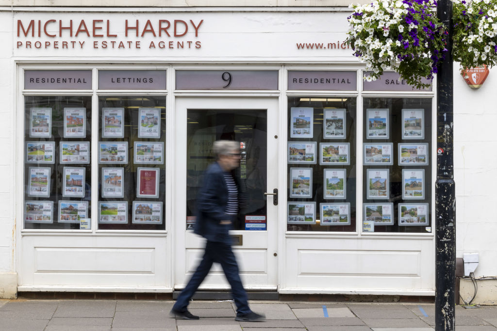Man walking past an estate agent