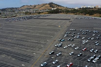 Half-empty parking lot of cars. 
