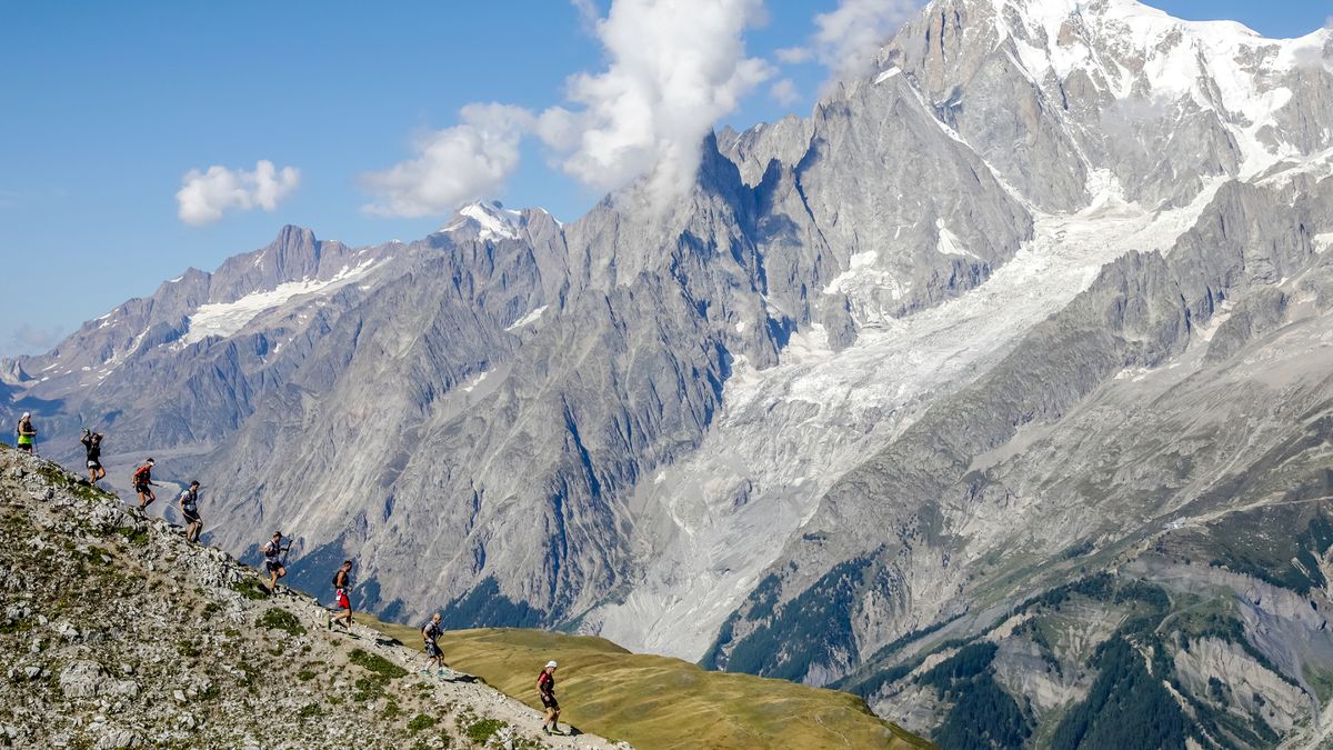 A group of trail runners running across a mountain