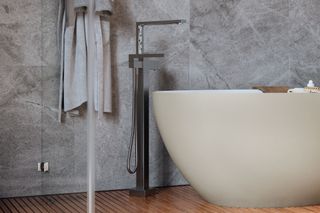 Curved freestanding bath with silver tap