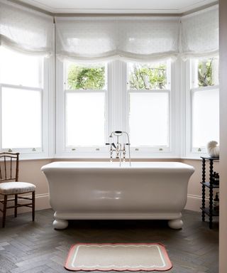 Neutral bathroom with freestanding bath in elegant period house in London