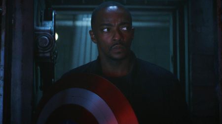 Anthony Mackie as Captain America Sam Wilson, in a dark room holding his famous shield, in Captain America: Brave New World.