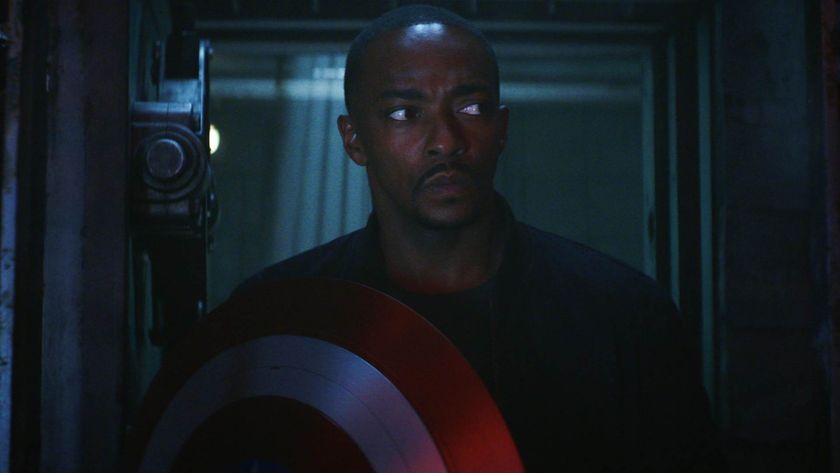 Sam Wilson in a dark room holding shield