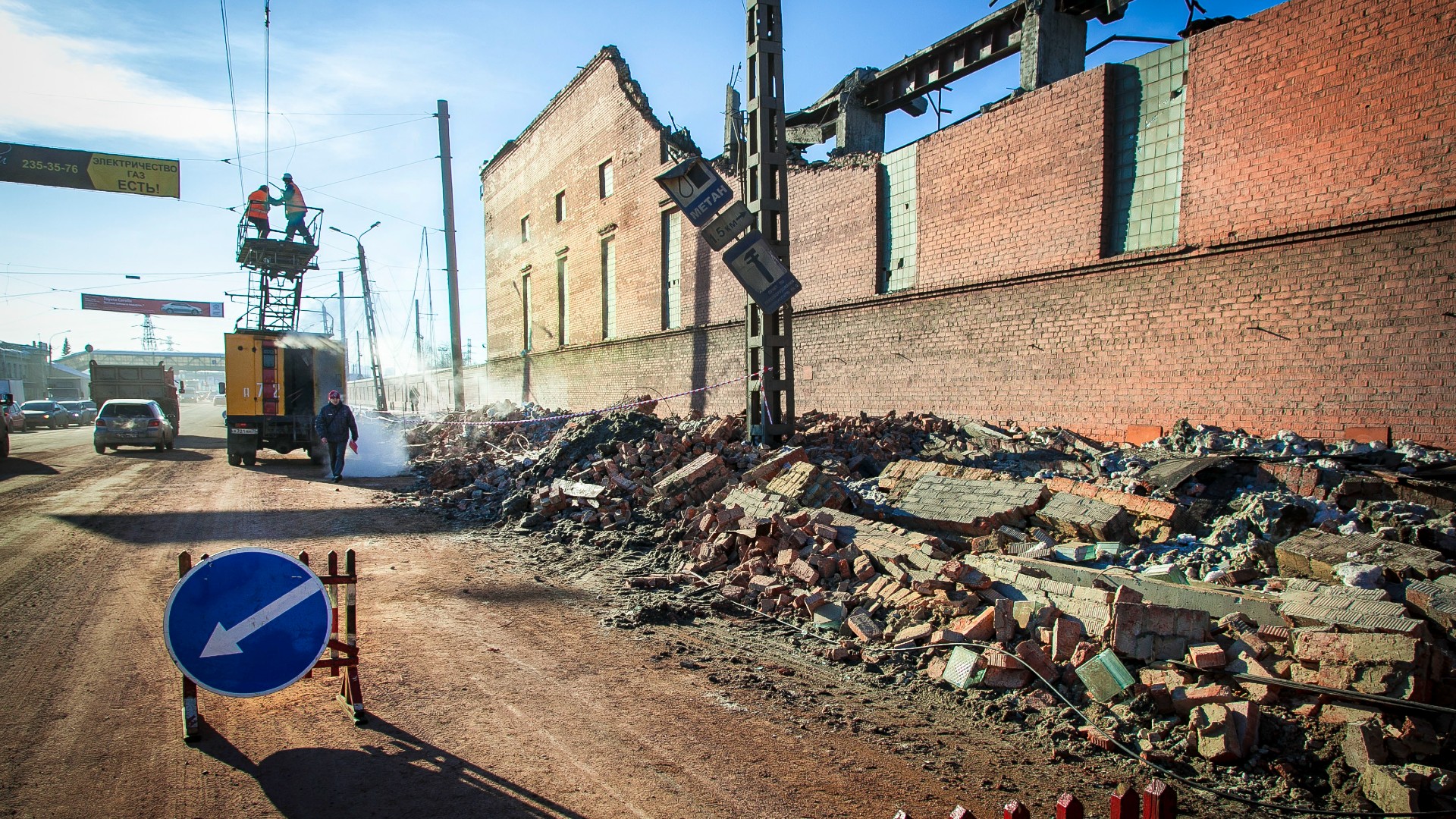 workers repair a broken brick wall