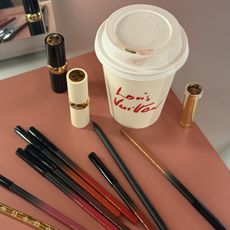 Photo of Louis Vuitton makeup products next to a branded coffee cup