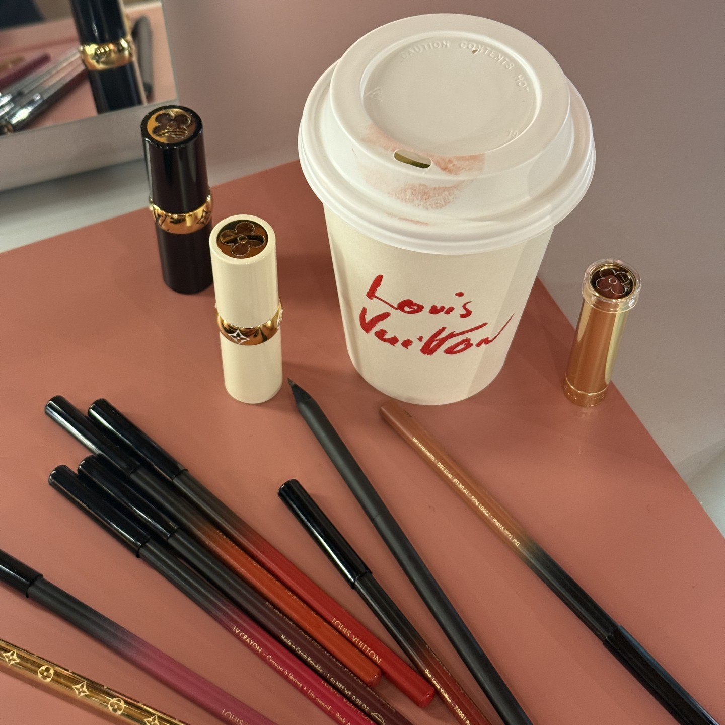 Photo of Louis Vuitton makeup products next to a branded coffee cup