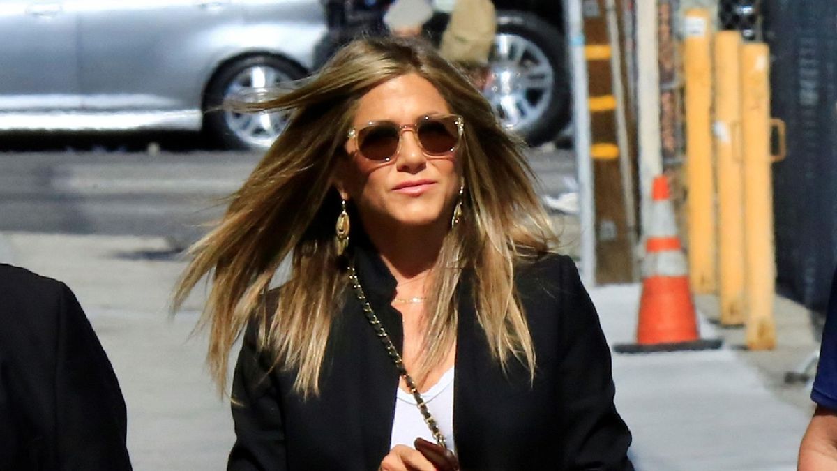 Jennifer Aniston donne une masterclasse en jean blanc coiffant avec un blazer surdimensionné, des bottes en cuir et un sac à main de créateur intemporel