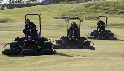 Greenkeepers mow a fairway