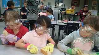 Girls learn how to measure properly for their woodworking projects.