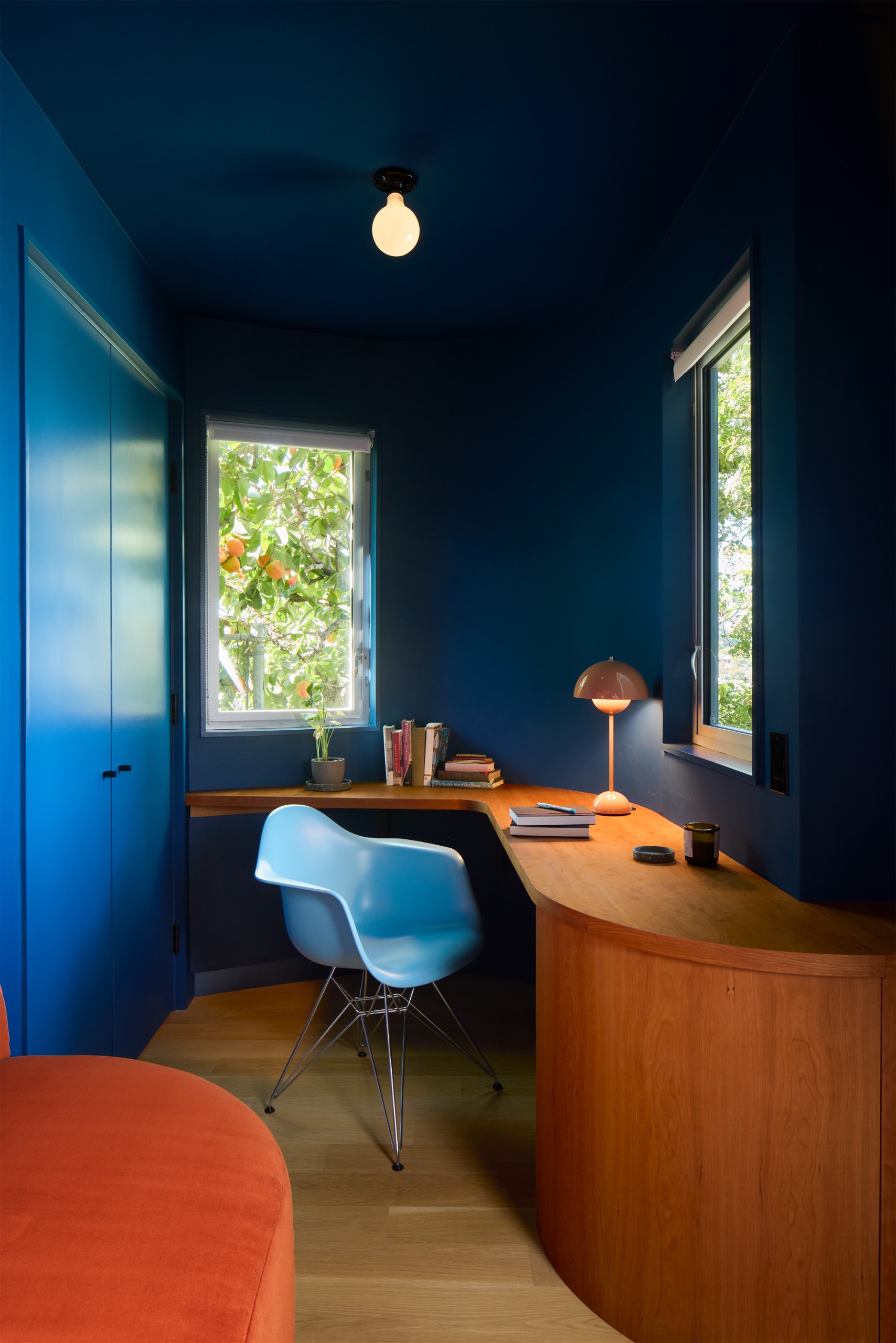 small home office with wraparound desk and dark blue walls