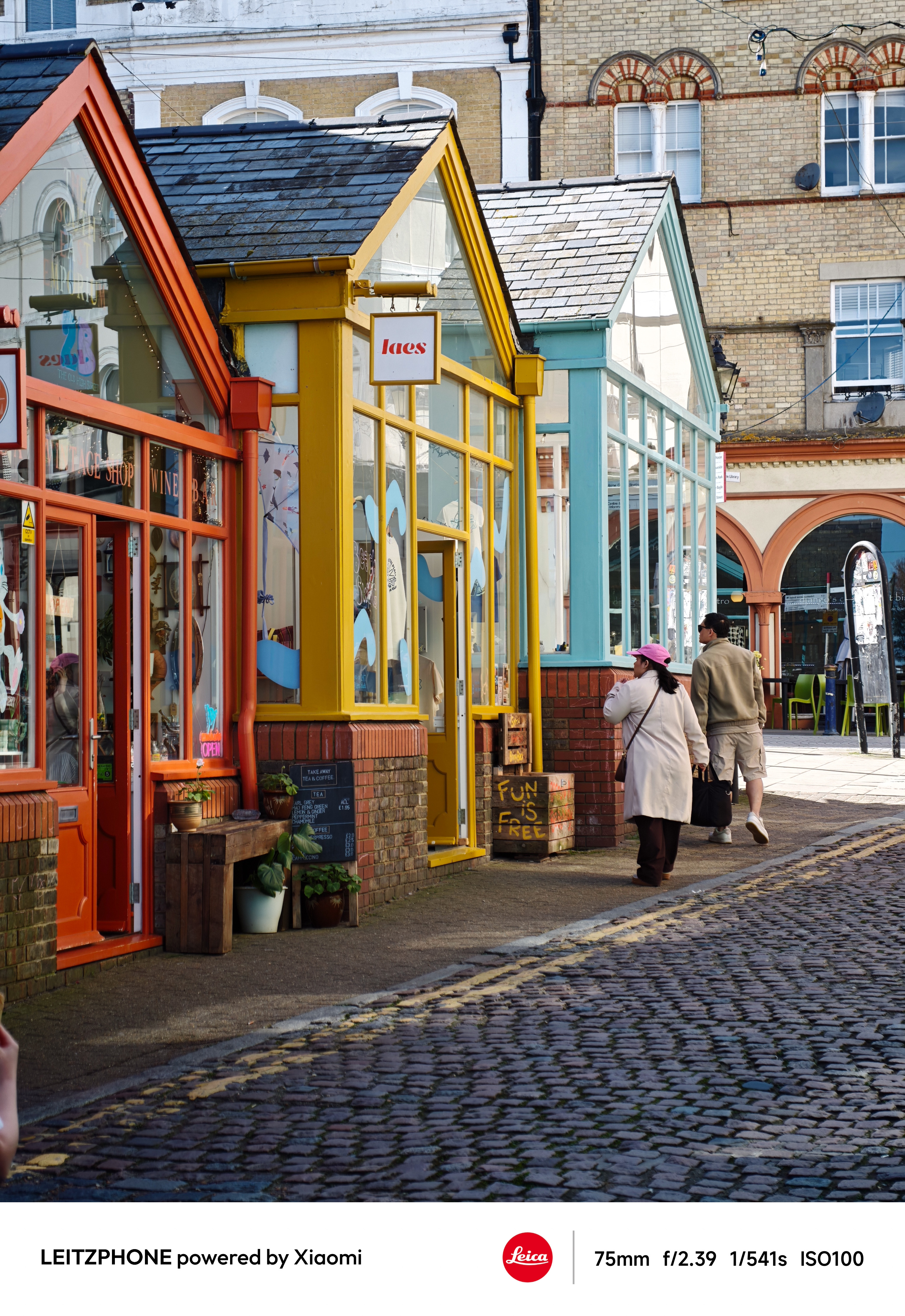 Colorful shopfronts along a cobbled street