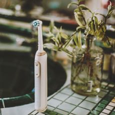 electric toothbrush on green bathroom sink area
