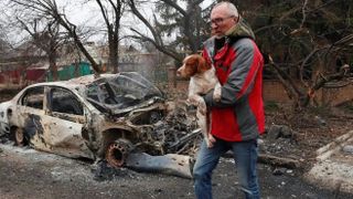 A man assisting dog to safety in Ukraine