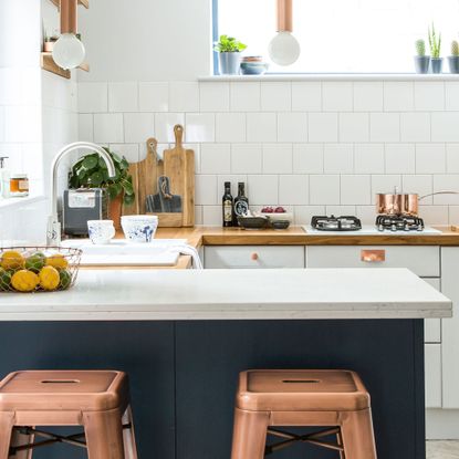 White small kitchen with kitchen island and copper stools