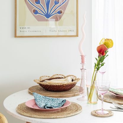 White dining table, rattan round placemats, candles