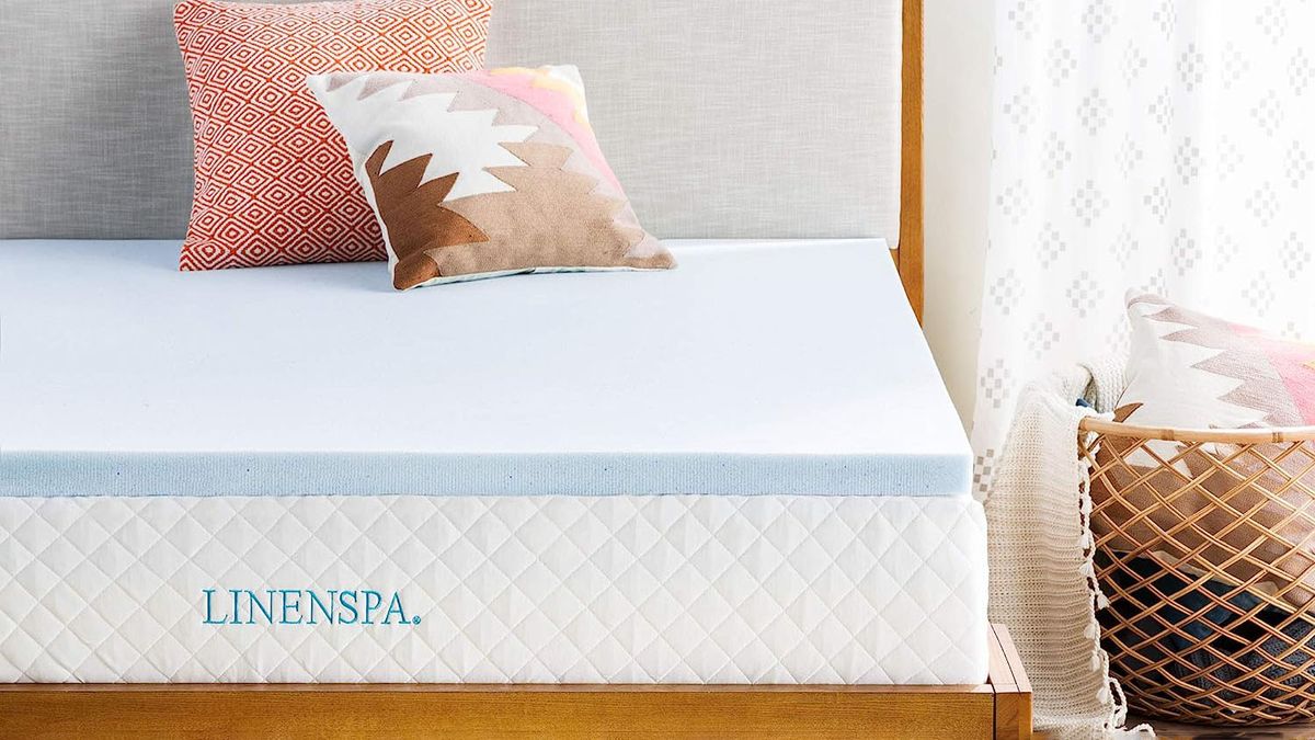 The Linenspa Memory Foam Mattress Topper on a bed in a sunny bedroom