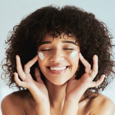 image of a smiling woman with cream on her cheeks - Best moisturiser