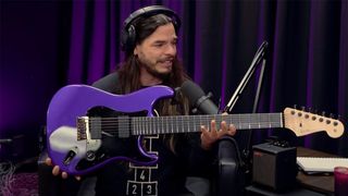 Chris Garza holding his seven-string Fender Stratocaster