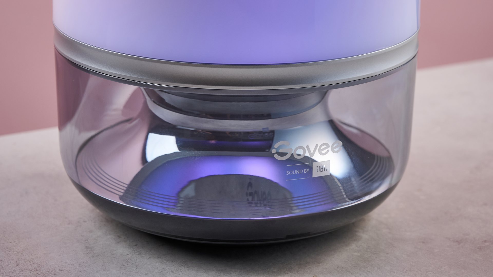 A close-up of the base of the Govee Table Lamp 2 Pro x Sound by JBL, which is reflecting the purple lights from above.